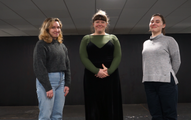 Three women standing in a room smiling