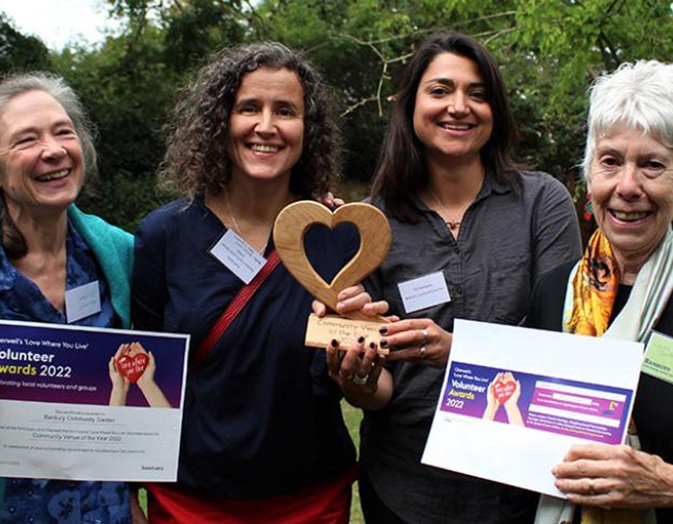 Four people holding awards Four people holding awards