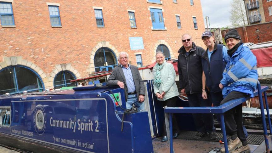 EMCBP and Tameside Canal Boat Trust volunteers Five people standing on a moored boat smiling