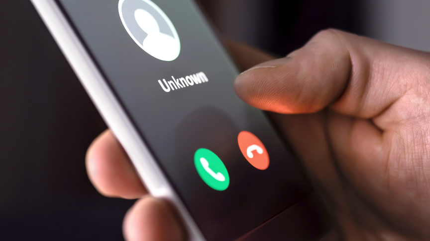 Scam A hand holding a phone that says 'unknown' on the screen